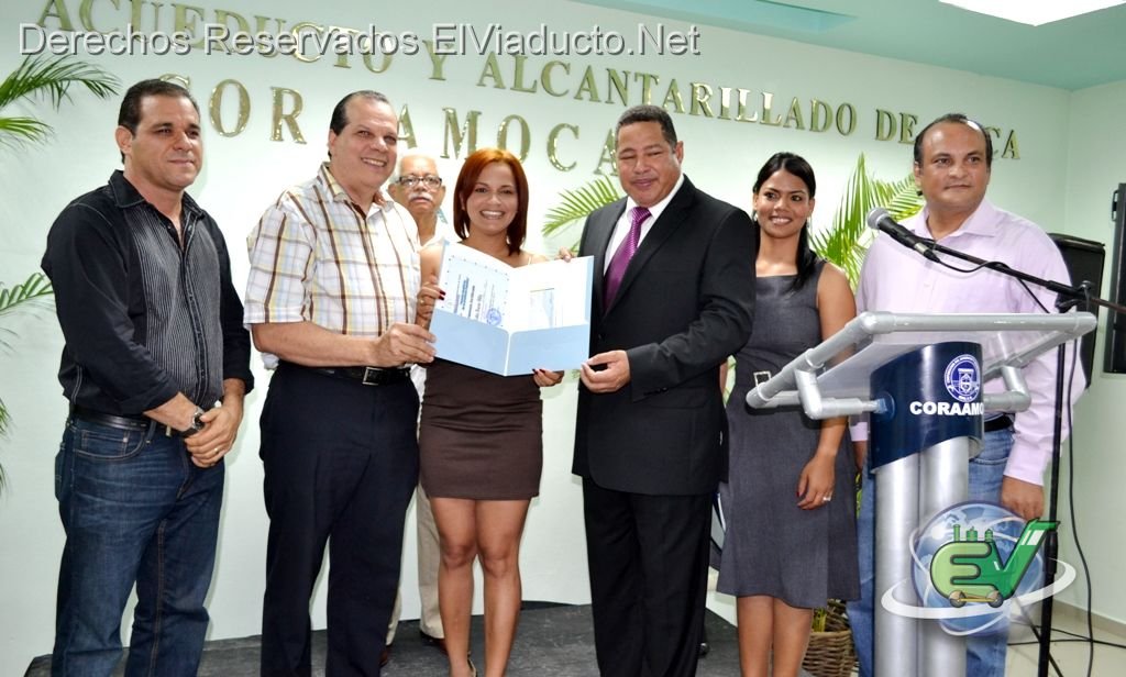 Entrega del certificado del primer Lugar a Olga Lidia Bueno, ganadora del primer lugar del concurso de fotografia de CORAAMOCA
